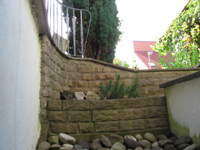 Lichtschachtabmauerung aus handgearbeiteten Bossensteinen - terassenfrmig angelegt - Abdeckplatten im Halbkreis und handgearbeiteter Bossenkante